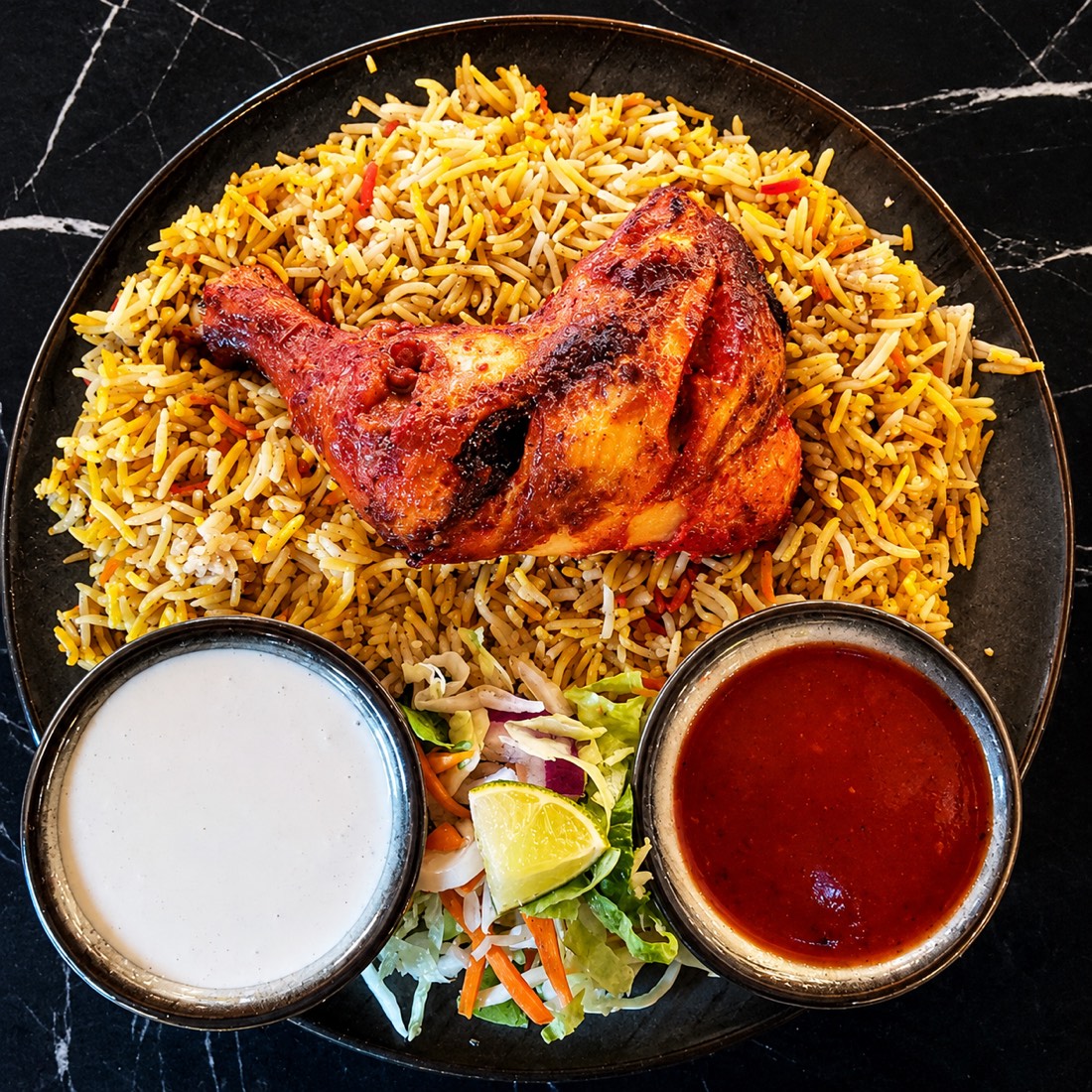 Al faham grilled chicken over saffron ghee rice with garlic and chilli sauces and fresh salad